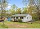 View of the side of a single-story home with chain-link fencing and mature trees at 2721 Thelma St, Durham, NC 27704