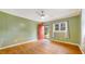 Bright living room with hardwood floors, ceiling fan, and a red front door at 2721 Thelma St, Durham, NC 27704
