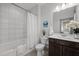 Bright bathroom with a shower-tub combination, a dark vanity and neutral colored tile at 282 Granite Mill Blvd, Chapel Hill, NC 27516