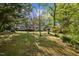 A view of the expansive backyard and back of house, lined by mature trees and greenery, offering a private retreat at 3014 Hope Valley Rd, Durham, NC 27707