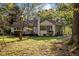 The rear of the home features a brick chimney, a deck with dark wood, and the lush green backyard at 3014 Hope Valley Rd, Durham, NC 27707