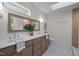 Bathroom features double sinks, decorative mirror, skylight and stone-look tile floors at 3014 Hope Valley Rd, Durham, NC 27707