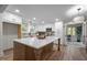Spacious kitchen with white cabinetry, a large central island, modern appliances, and wood floors at 3014 Hope Valley Rd, Durham, NC 27707