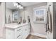 Bright bathroom featuring a white vanity with modern fixtures and a large mirror, plus a window for natural light at 305 E First St, Princeton, NC 27569