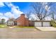 Home exterior with a detached two car garage, well-maintained lawn, and classic brick details at 305 E First St, Princeton, NC 27569