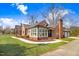 Rear view of a brick home, detached garage, and a well-maintained yard with mature trees at 305 E First St, Princeton, NC 27569