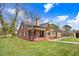 Brick home with an inviting front porch, lush green lawn, and classic architectural details at 305 E First St, Princeton, NC 27569