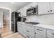 Well-equipped kitchen with stainless steel appliances, dark cabinets, and wooden flooring at 305 E First St, Princeton, NC 27569
