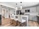 Contemporary kitchen featuring a long quartz countertop island with bar stools and pendant lighting at 305 E First St, Princeton, NC 27569