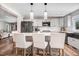 Kitchen features a bar with white cushioned stools, white subway tiles, and stainless steel appliances at 305 E First St, Princeton, NC 27569