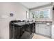 Modern laundry room with washer, dryer, sink, countertop, and white cabinets at 305 E First St, Princeton, NC 27569