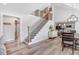 Open staircase leads to a vaulted ceiling living room with a view of kitchen at 305 E First St, Princeton, NC 27569