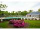 Community pool surrounded by greenery and a nearby building with a blue roof at 3336 Tarleton W, Durham, NC 27713