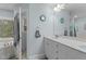 Light and airy bathroom featuring a double vanity, large mirror, and tiled floor and tub at 402 Green Turret Dr, Rolesville, NC 27571