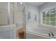 Inviting bathroom showcasing a relaxing soaking tub next to a window and a separate shower at 402 Green Turret Dr, Rolesville, NC 27571