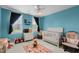 bedroom with bright blue walls, white furniture, and a cozy rocking chair at 402 Green Turret Dr, Rolesville, NC 27571
