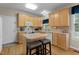 Functional kitchen with light wood cabinets, an island with bar stools, and modern appliances at 402 Green Turret Dr, Rolesville, NC 27571