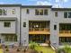 Rear view of modern townhomes with balconies, patios, and well-kept backyard landscaping at 4504 Mint Leaf Ln, Raleigh, NC 27612