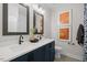 Elegant bathroom featuring double sinks, navy blue vanity, and modern art at 4504 Mint Leaf Ln, Raleigh, NC 27612