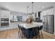 Bright kitchen boasts stainless appliances, white cabinets, quartz counters, and an island with barstool seating at 4504 Mint Leaf Ln, Raleigh, NC 27612