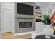 Living room showing modern fireplace, wall-mounted TV and built-in shelves with decor at 4504 Mint Leaf Ln, Raleigh, NC 27612