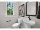 Well-lit powder room features a pedestal sink, toilet, and modern fixtures at 4504 Mint Leaf Ln, Raleigh, NC 27612