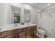 This bathroom features a double vanity, two mirrors, and a toilet with a patterned shower curtain at 4524 Flat Bastion Drive Dr, Raleigh, NC 27610