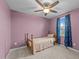 Cozy bedroom featuring carpet, ceiling fan, and a window with blue curtains at 4524 Flat Bastion Drive Dr, Raleigh, NC 27610