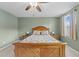 Bright bedroom with a wooden bed frame, soft carpet, and a ceiling fan creating a calm and inviting space at 4524 Flat Bastion Drive Dr, Raleigh, NC 27610