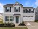 Charming two-story home features a well-manicured lawn, attached two-car garage, and a welcoming teal front door at 4524 Flat Bastion Drive Dr, Raleigh, NC 27610