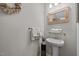 Elegant powder room featuring pedestal sink, wood-framed mirror, and decorative wreath at 4803 Stony Falls Way, Knightdale, NC 27545