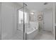 Bright bathroom featuring a glass-enclosed shower and a large soaking tub at 4803 Stony Falls Way, Knightdale, NC 27545