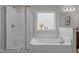 Bright bathroom featuring a glass-enclosed shower and a large soaking tub at 4803 Stony Falls Way, Knightdale, NC 27545
