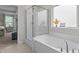 Bright bathroom featuring a glass-enclosed shower and a large soaking tub at 4803 Stony Falls Way, Knightdale, NC 27545