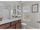 Well-lit bathroom featuring a double sink vanity, framed mirror, and window for natural light at 4803 Stony Falls Way, Knightdale, NC 27545