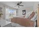 Cozy bedroom with a ceiling fan, large window, and comfortable bed, creating a relaxing atmosphere at 4803 Stony Falls Way, Knightdale, NC 27545