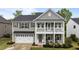Charming two-story home with a welcoming front porch and a two-car garage, showcasing classic architectural details at 4803 Stony Falls Way, Knightdale, NC 27545