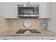 Modern kitchen with sleek black cooktop, stainless microwave, and designer backsplash at 4803 Stony Falls Way, Knightdale, NC 27545