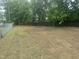 Expansive backyard with lush trees and a chainlink fence, offering plenty of space and seclusion at 500 John St St, Clayton, NC 27520