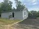 Exterior view of renovated gray home with a black front door and fresh black topcoat driveway at 500 John St St, Clayton, NC 27520