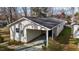 Aerial view of house with covered parking, black roof, and surrounding trees at 505 E Graham St, Mebane, NC 27302
