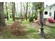 The backyard provides ample shade with mature trees, as well as flowering bushes and a sundial at 505 E Graham St, Mebane, NC 27302
