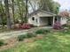 Back view of a home featuring covered parking and landscaped yard with colorful azaleas at 505 E Graham St, Mebane, NC 27302