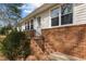 Charming home exterior with brick stairs and white door under an overhang at 505 E Graham St, Mebane, NC 27302