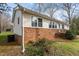 Home exterior featuring brick foundation, white siding, and mature landscaping at 505 E Graham St, Mebane, NC 27302