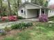 The home features a covered carport and a gravel driveway with landscaping and mature plantings at 505 E Graham St, Mebane, NC 27302