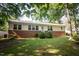 Ranch style home with brick and vinyl siding, manicured lawn and mature trees offering curb appeal at 505 E Graham St, Mebane, NC 27302