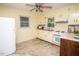 Bright kitchen with tile flooring, plentiful cabinets, white appliances, and natural light at 505 E Graham St, Mebane, NC 27302