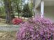 Bright purple azaleas are planted near the home next to a mature forest of trees at 505 E Graham St, Mebane, NC 27302