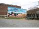 A mural of the Muffins Ice Cream Shoppe featuring sunflowers and black and white cows at 505 E Graham St, Mebane, NC 27302